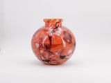 a red vase with a black and white design on it