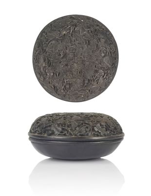 a black plate with a silver lid on a white surface
