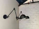 a lamp that is on the wall next to a chair