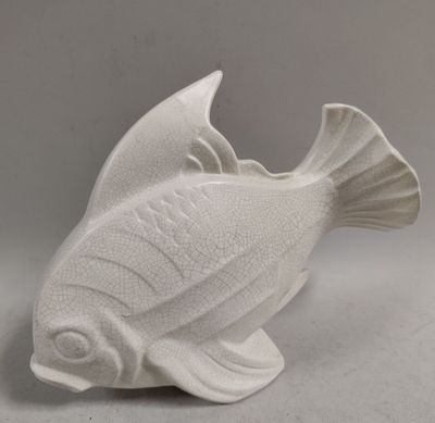 a white ceramic fish that is sitting on a table