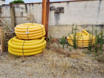 a pile of yellow hoses sitting next to a building