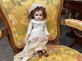 a doll that is sitting on a chair in a room