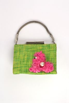 sac à main vert et rose orné d'une fleur rose sur le devant