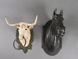 two animal heads mounted on the wall next to each other