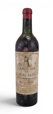 une vieille bouteille de vin posée sur une surface blanche
