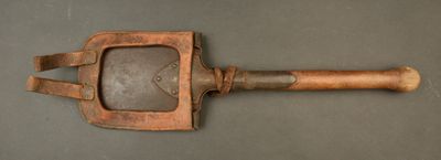 an old wooden spatula with a wooden handle on a gray surface