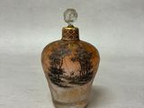 une petite bouteille en verre décorée d'une peinture