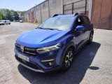La voiture bleue est garée sur le parking près d'un immeuble.