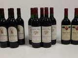 six bottles of red wine are lined up on a white surface