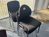 two black chairs in the corner of a room with a red chair