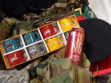 many cans of sodas and cans of coke on a bed