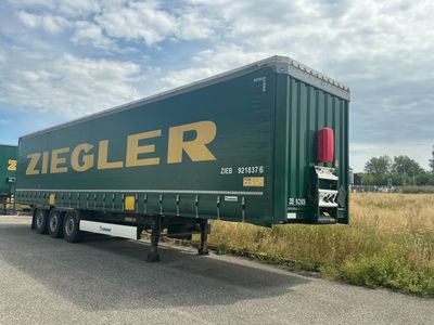une semi-remorque verte garée sur le bord de la route
