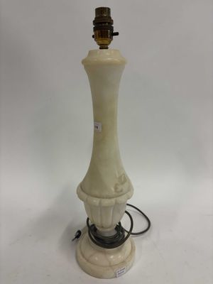 une lampe blanche surmontée d'un abat-jour marron