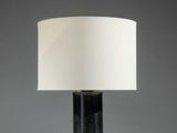 une lampe de table noire et blanche, surmontée d'un abat-jour blanc