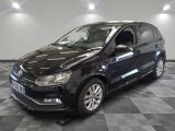 the black volkswagen polo is parked on a checkered tile floor