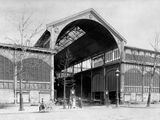 black and white photo of an old train station with people walking around