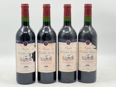 trois bouteilles de vin rouge sont alignées sur une surface blanche
