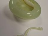 a green bowl with a worm in it on a table