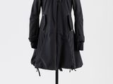 un manteau noir posé sur un mannequin, sur fond blanc