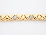 a yellow gold bracelet with diamonds on a white background
