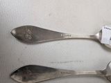 two spoons that are sitting next to each other on a table
