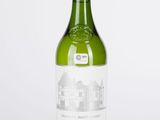 la bouteille de vin blanc est posée sur une surface blanche