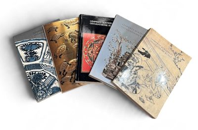 several books are stacked on top of each other on a white surface