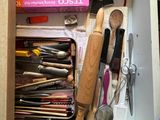 a drawer full of kitchen utensils and other items