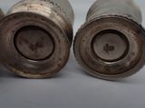 two silver vases sitting next to each other on a table