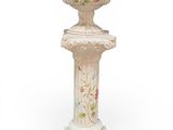 a white vase with a floral design on it