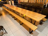 une longue table en bois avec des bancs au milieu de la pièce