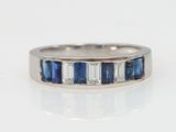 a close up of a white gold ring with blue and white stones