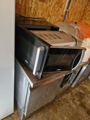 un réfrigérateur et un micro-ondes placés l'un à côté de l'autre dans une pièce