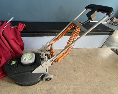a machine that is sitting on the floor next to a red bag