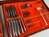 a tray filled with silverware and utensils on a table