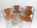 four wooden chairs sitting on top of a white floor next to each other