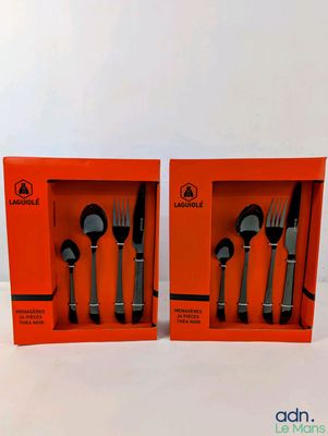 two orange boxes with forks and spoons in them on a white surface