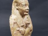 an ancient egyptian statue of a woman holding a baby
