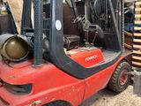 a red forklift truck parked in a garage