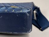 an old blue suitcase sitting on top of a white table