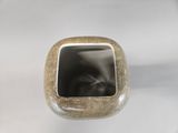 a small square vase with a black cat inside of it