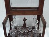 a glass display case with a lot of glasses in it