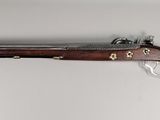 gros plan d'un pistolet sur une surface blanche