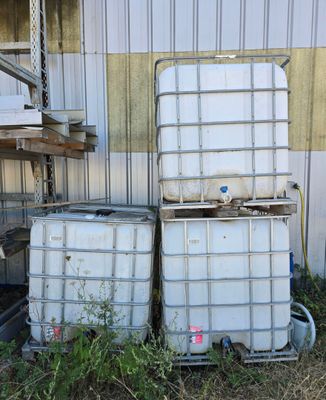 two white containers stacked on top of each other in the grass