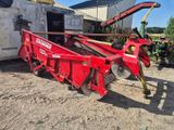 un tracteur rouge avec une remorque attelée à l'arrière