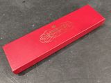 a close up of a red box on a table with a black background