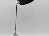 un gros plan d'une lampe noire posée sur une surface blanche