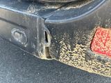 a close up of a dirty car with a red sticker on it