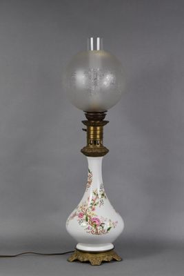 a white and gold lamp with a glass shade on top of it