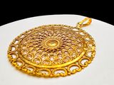 an image of a gold plated pendant on a white surface